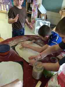 boys rolling out pizza dough